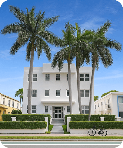 White building with palm trees in tropical setting